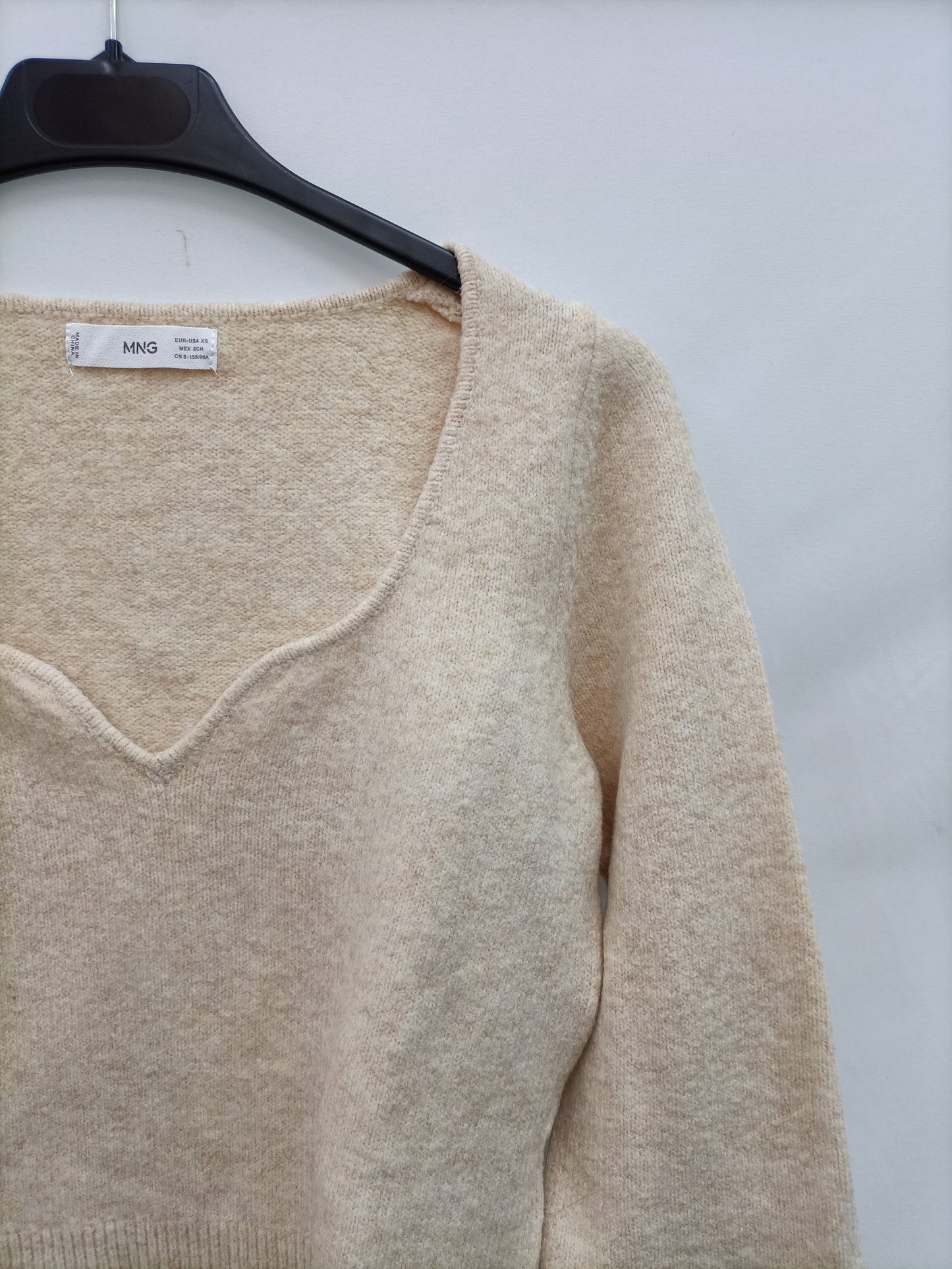 MANGO. Beige sweater with a V-neckline.