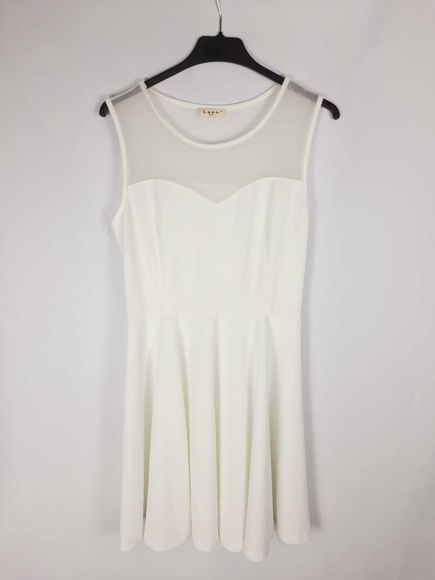 LANA PARIS. White dress with a flowing, semi-sheer neckline.