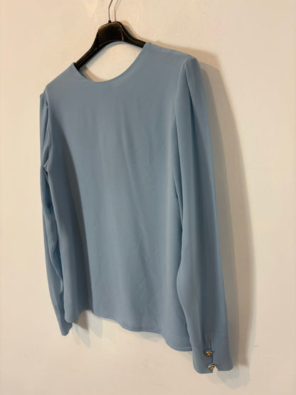BIMANI. Blusa azul claro espalda abotonada
