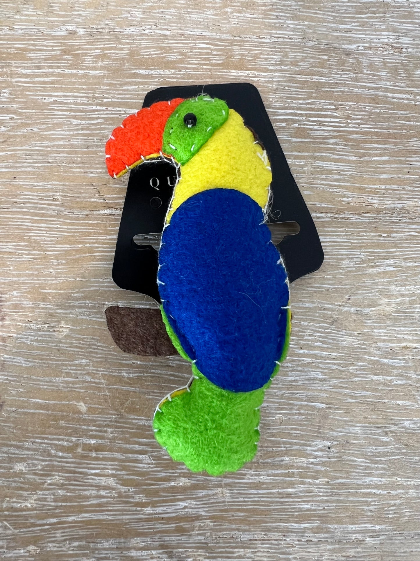 OTRAS. Broche loro tela colores