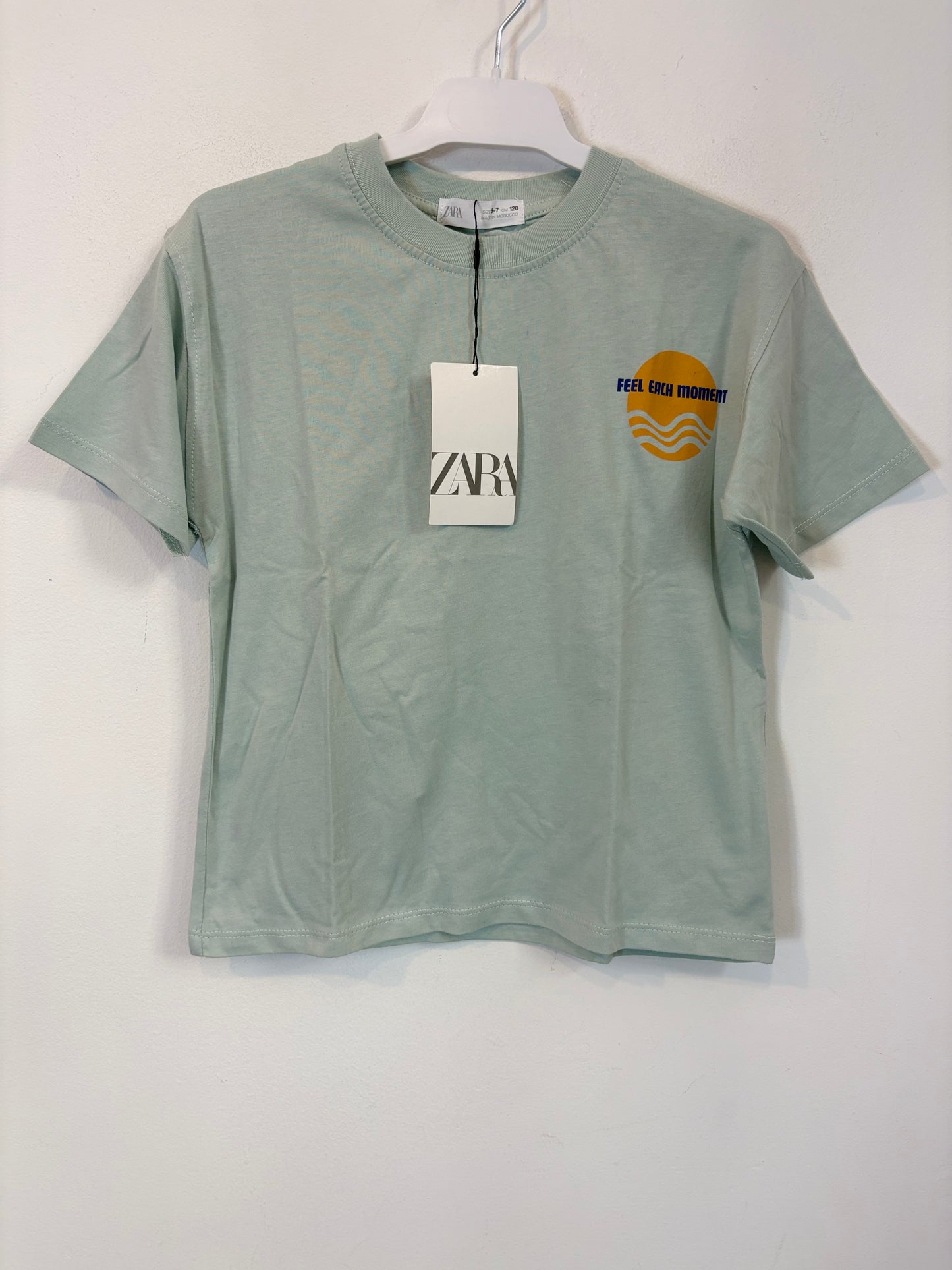 ZARA. Camiseta tono azul claro dibujos. T 6-7 años