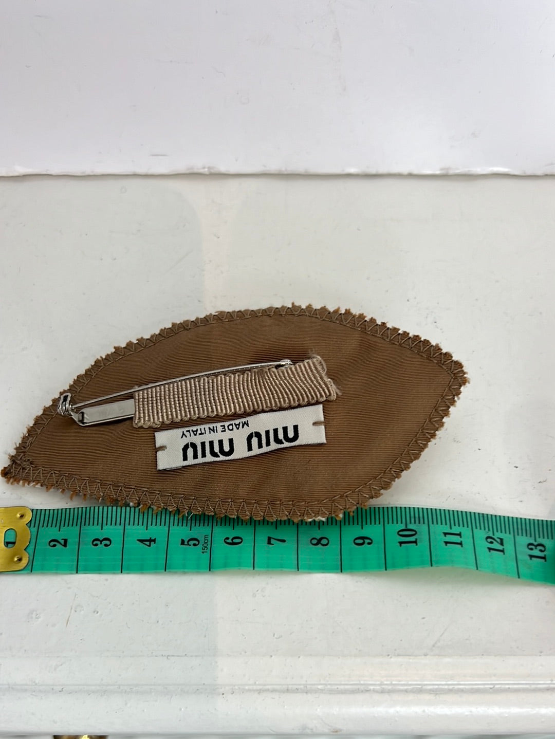 MIU MIU. Broche tela y pedrería
