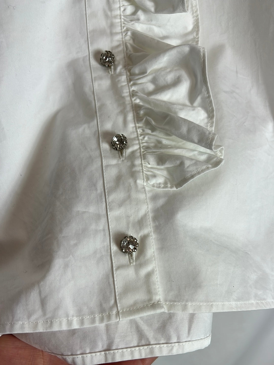 OTRAS. Blusa blanca volante y botones pedrería. T S