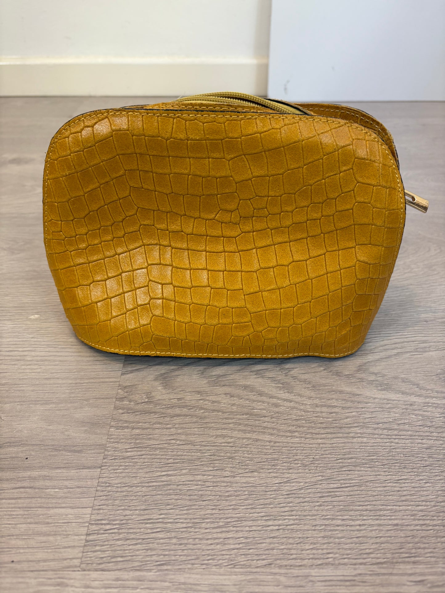 OTRAS. Bolso piel mostaza troquelado