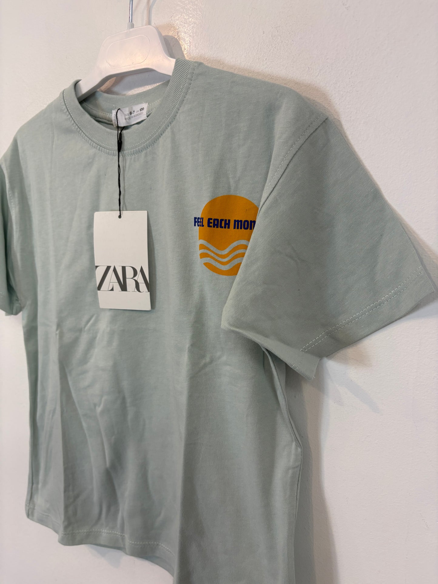 ZARA. Camiseta tono azul claro dibujos. T 6-7 años