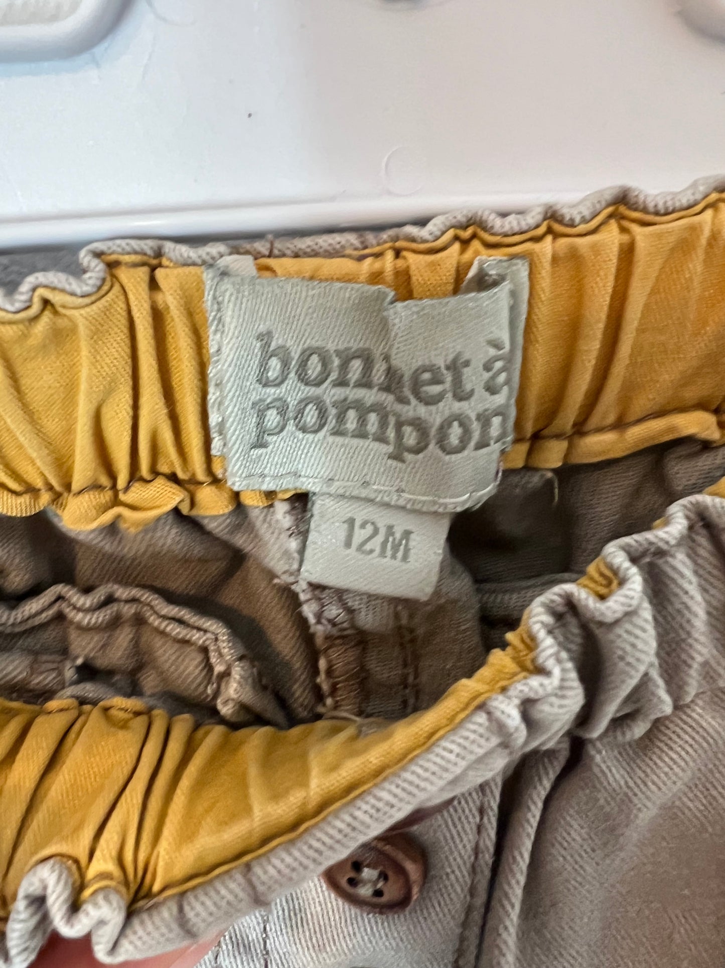 BONNET Á POMPON. Pantalón beige botones. T 12 meses