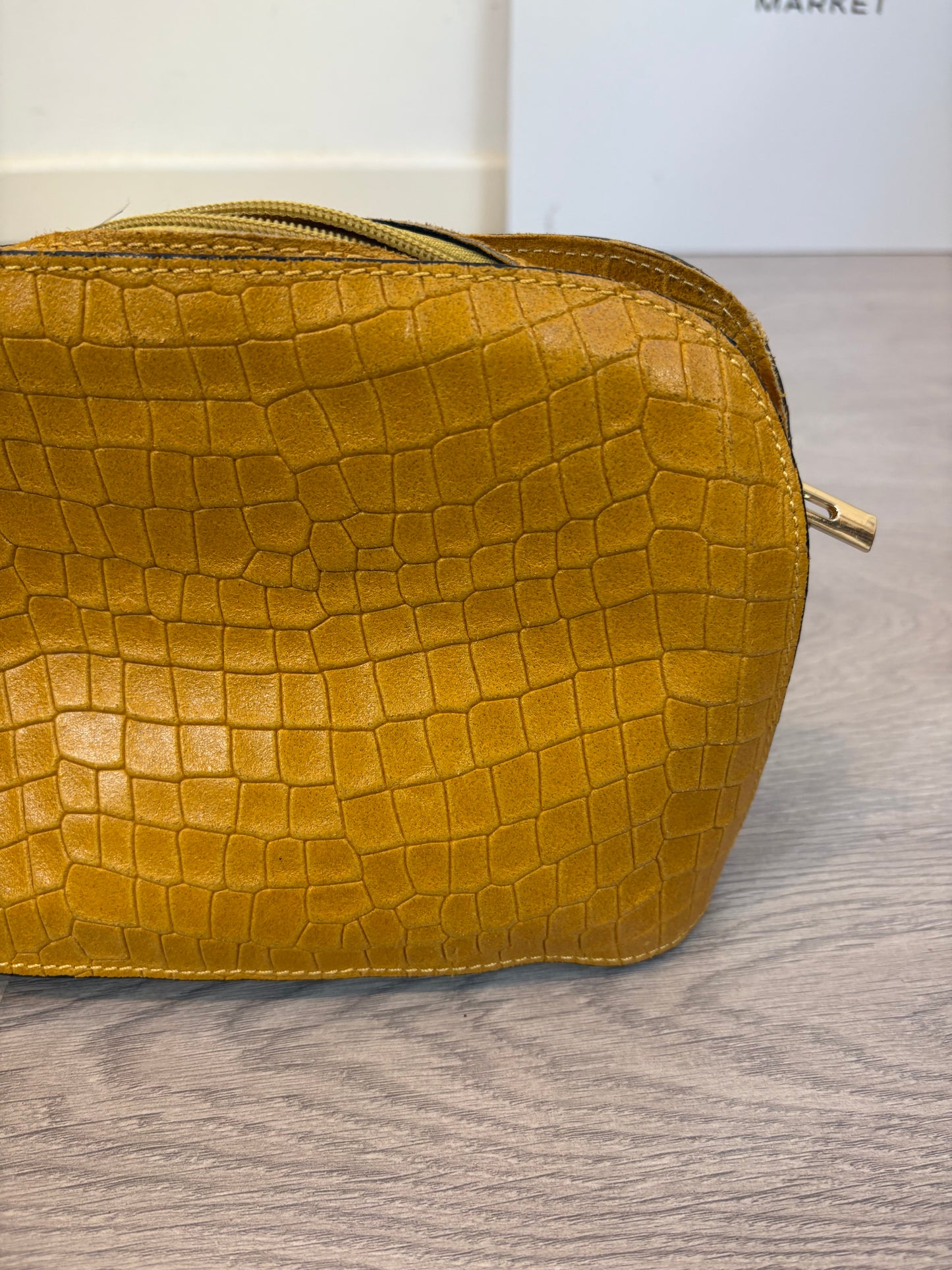 OTRAS. Bolso piel mostaza troquelado