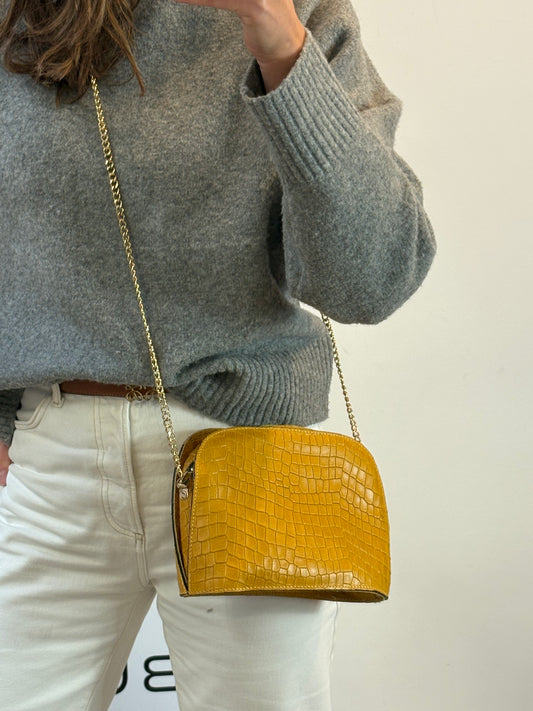 OTRAS. Bolso piel mostaza troquelado