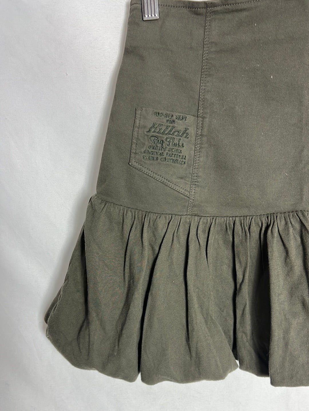 KILLAH. Short green ruffled skirt. TL