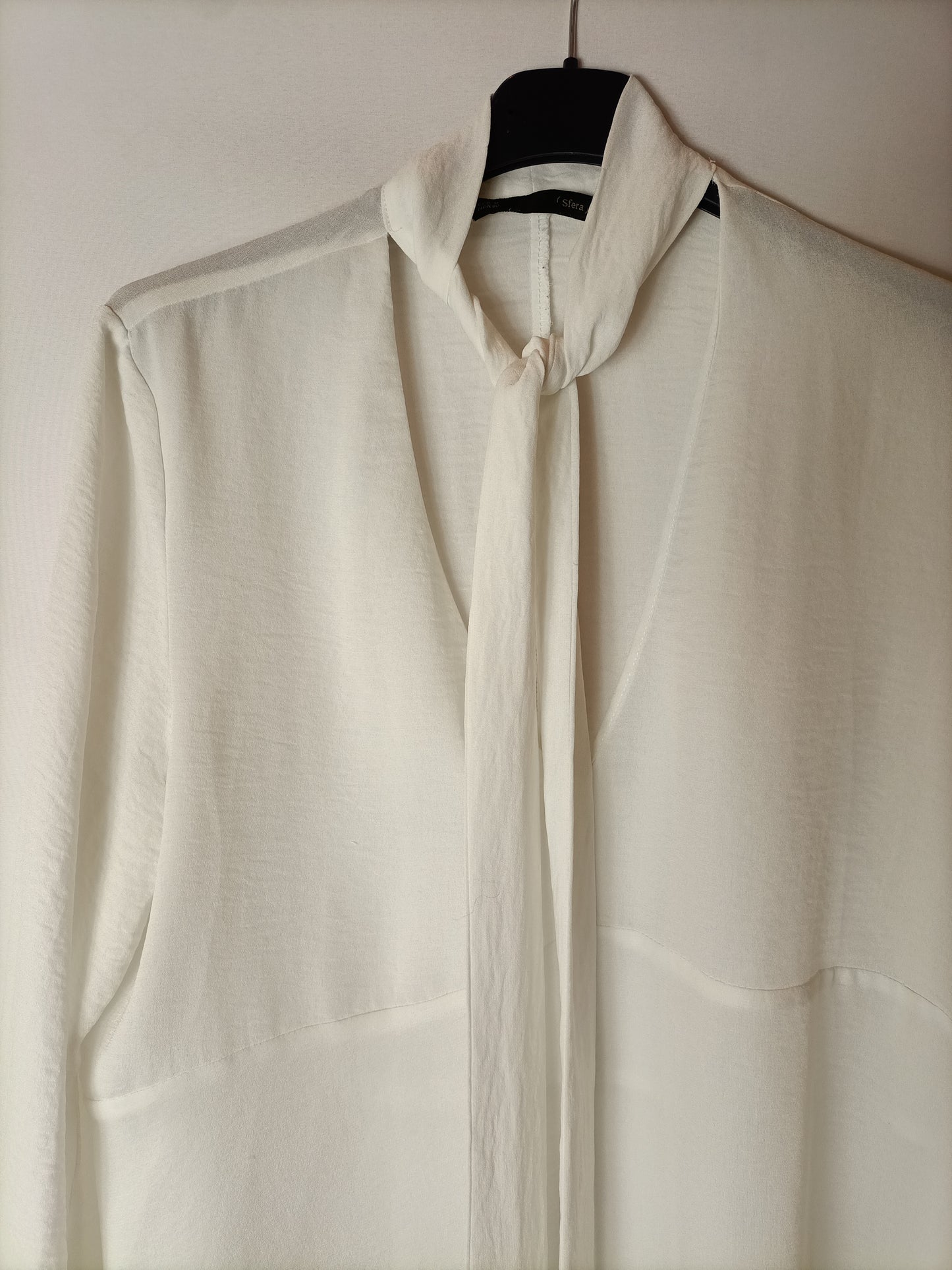 SFERA. White semi-sheer blouse with a bow at the neck. TM