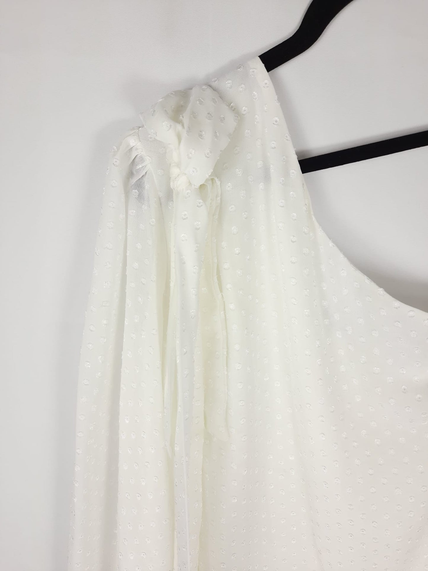 BRUNA. White asymmetrical top with Ts polka dots